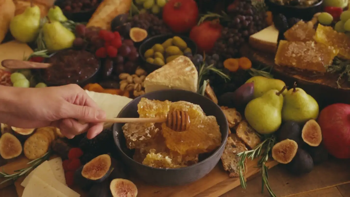 Honeycomb on a wooden board, honey dripping from a dipper